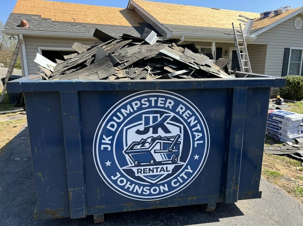 A JK Dumpster Rental roll-off container loaded and ready for pickup on a residential driveway in Johnson City, TN